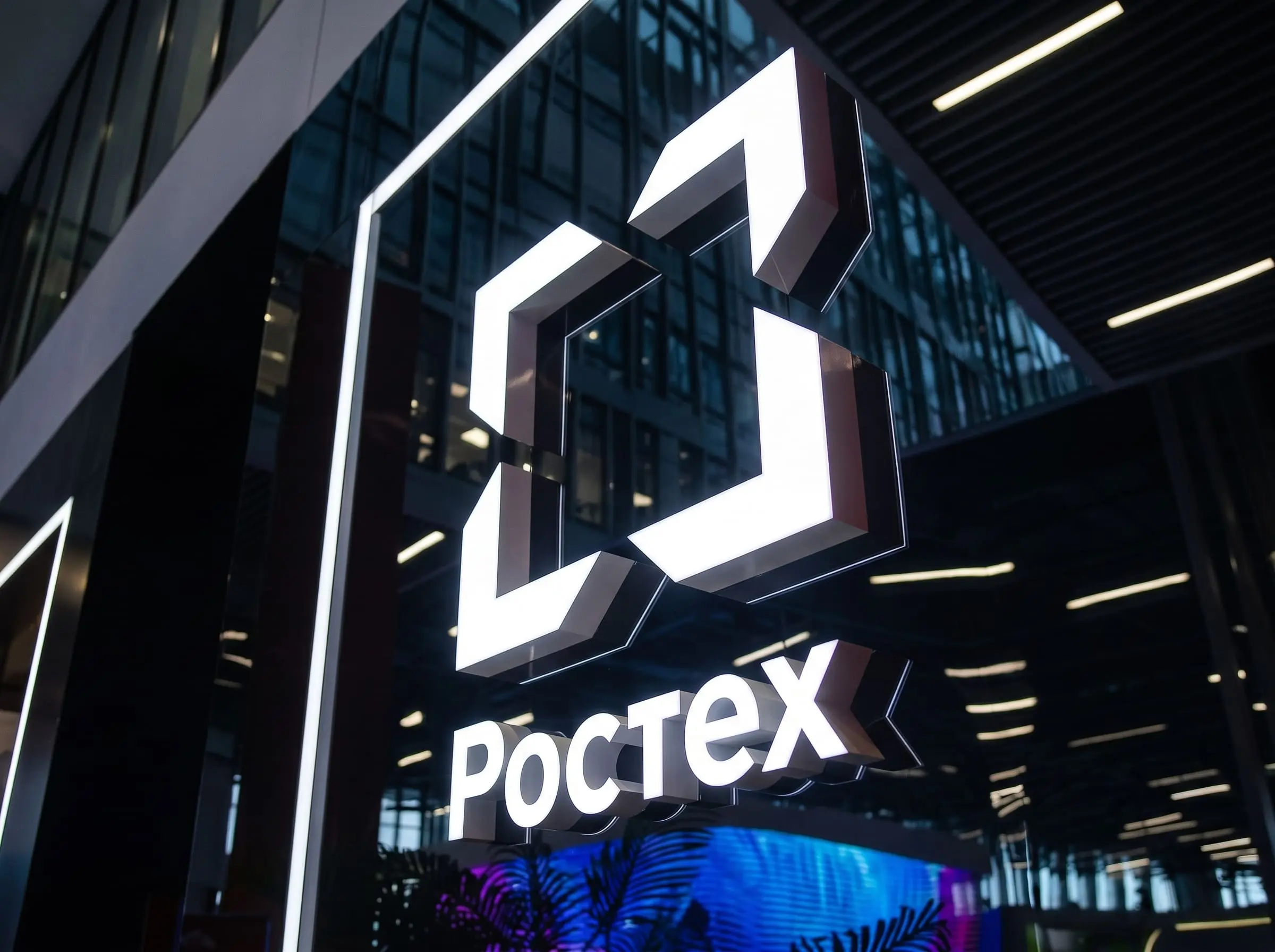 Комплексная техническая поддержка ЦОД для Ростех Изображение светящейся белой надписи Ростех на фасаде
