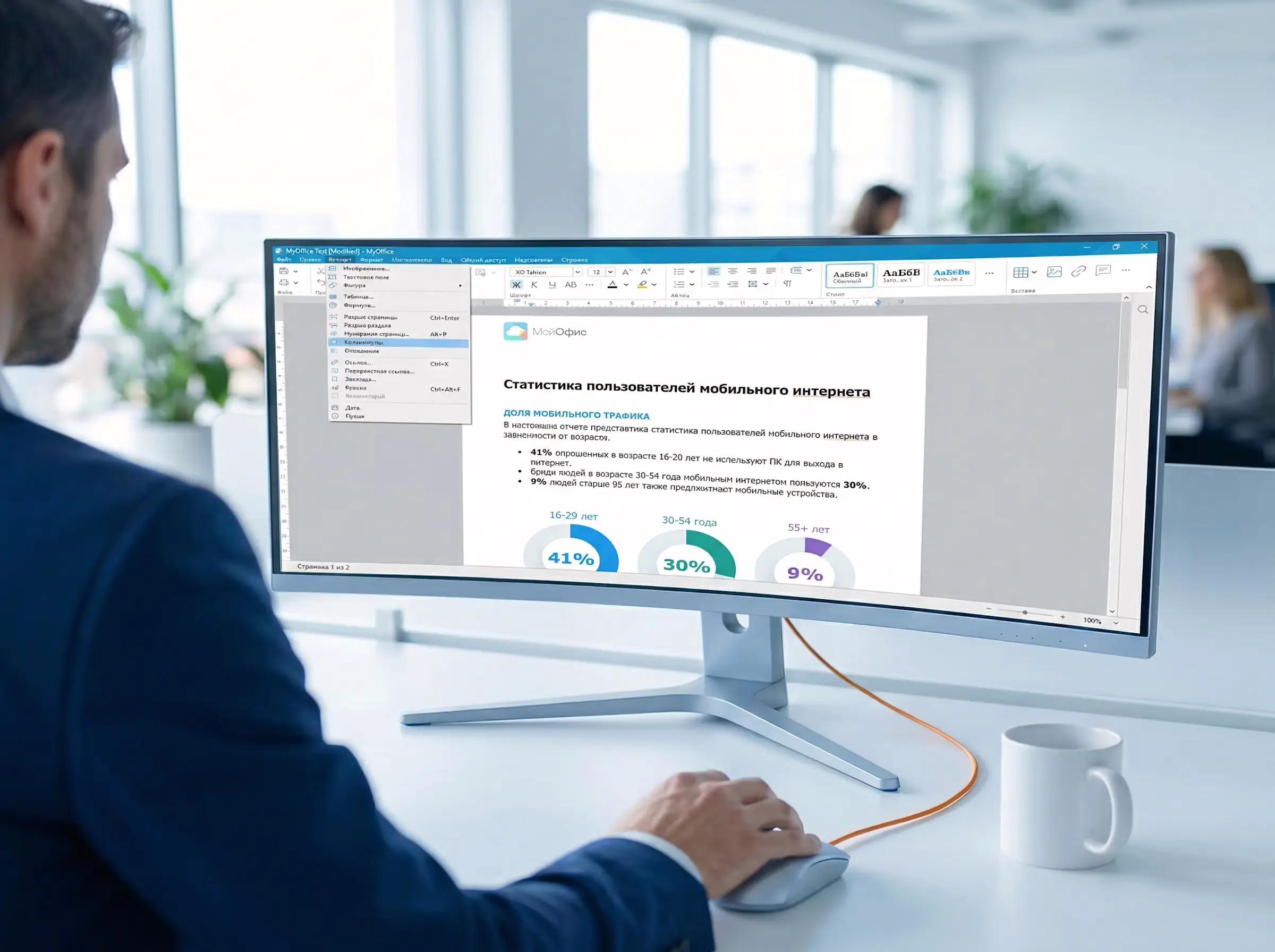 Сотрудник сидит за рабочим столом, на мониторе открыт интерфейс МойОфис